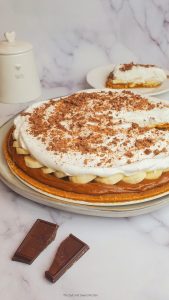 banoffee pie on a white plate with digestive biscuits