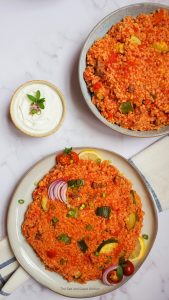 bulgur pilaf with zucchini on a serving plate with a cup of plain yogurt